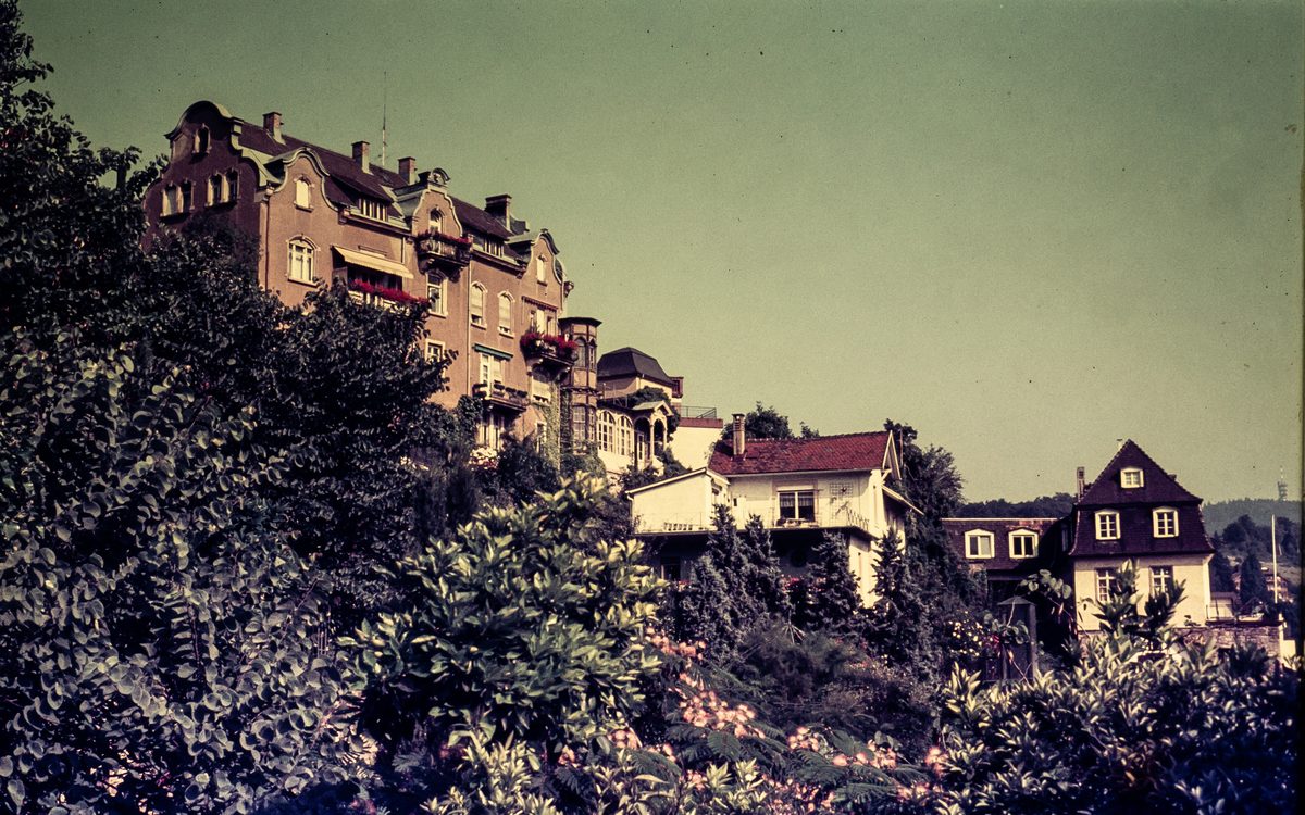 Villen und ein größeres Wohnhaus an einem bewaldeten Hang in Baden-Baden, auf einem verblassten Farbdia
